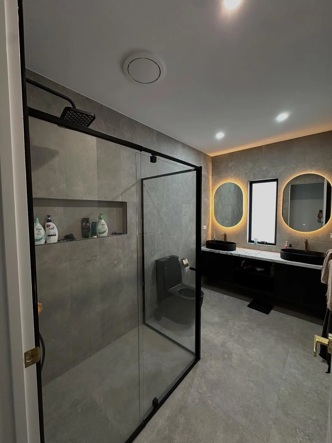 Dark tiled bathroom with freestanding bath