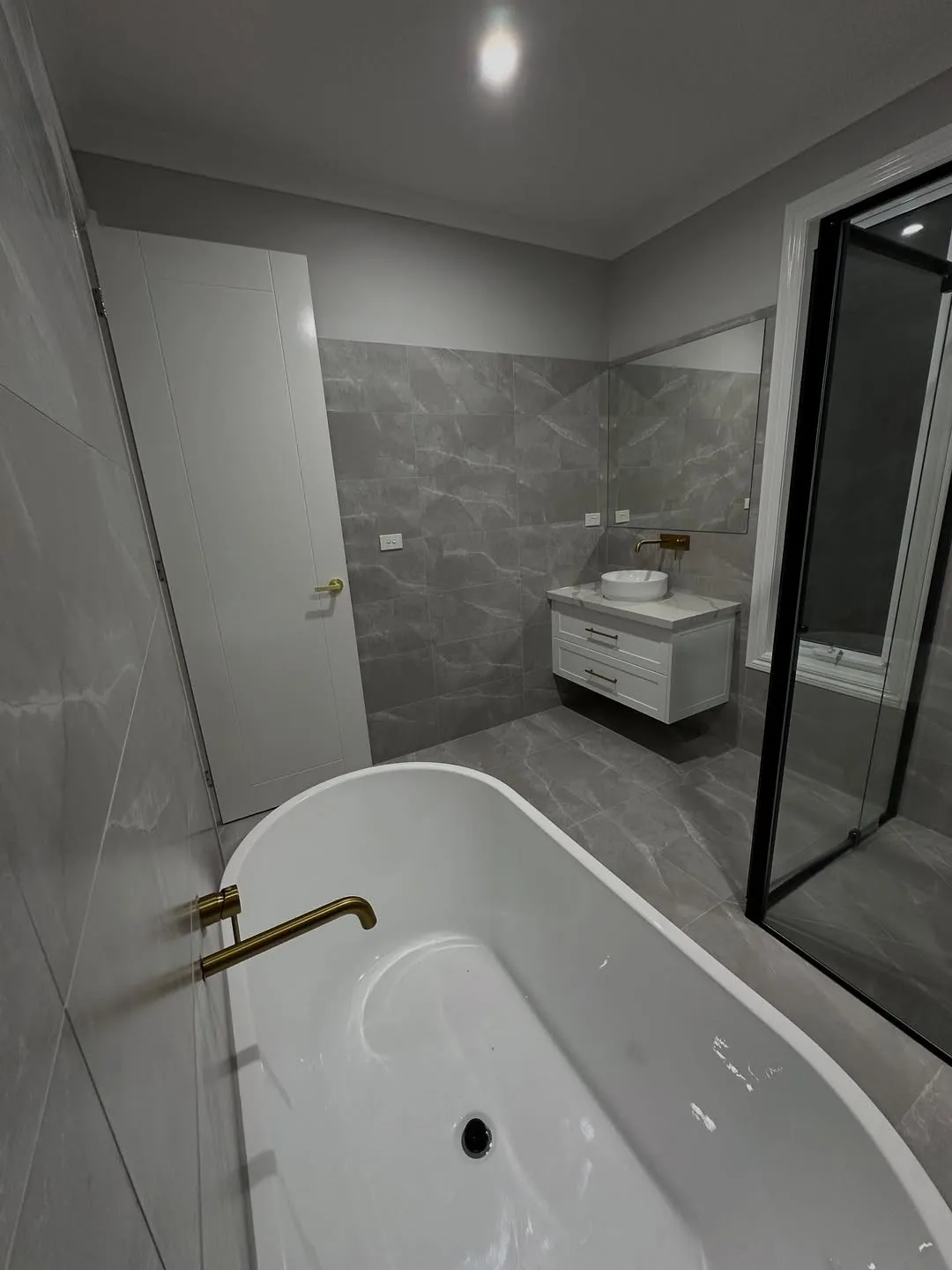 Grey bathroom with brushed gold tapware
